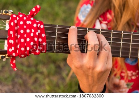 close-up woman hands playing the guitar