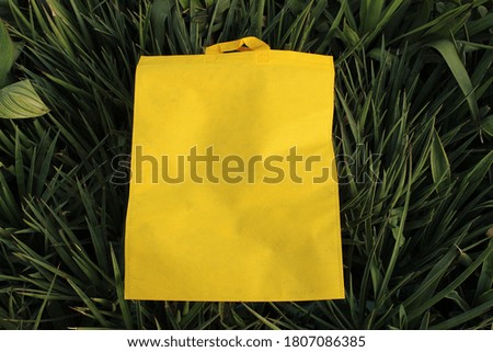 mock-up yellow bag isolated in green grass 