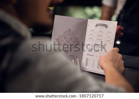 a man reads the menu in the bar, close-up of the menu and hands. Royalty-Free Stock Photo #1807120717