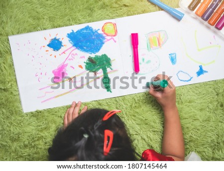 Child kid doing drawing picture with color crayons