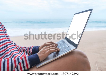 Woman using laptop and smartphone to work study in vacation day at beach background. Business, financial, trade stock maket and social network concept.