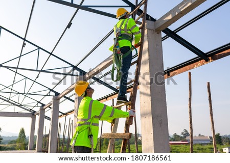 Safety height equipment in the construction site; Asian worker wear safety height equipment to install the roof. Fall arrestor device for worker with hooks for safety body harness. Royalty-Free Stock Photo #1807186561