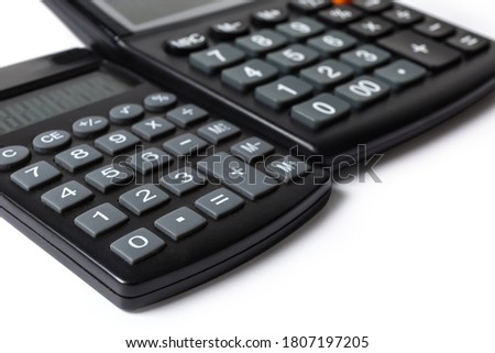 Keyboards of two different modern electronic calculators on a white background, fragment close-up in selective focus
