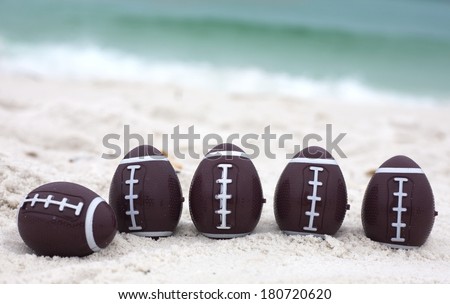 Easter eggs in shape of football balls on ocean beach