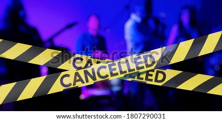 Concert cancelled, Barrier tape with the  word "CANCELLED" and Band in background Royalty-Free Stock Photo #1807290031