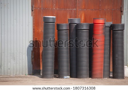 Plastic pipes for waste sewerage. Building material for laying ventilation pipes. Corrugated pipes are on the street.