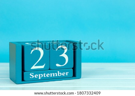 wooden calendar with the date of August 23 on a blue wooden background, International Day of Sign Languages
