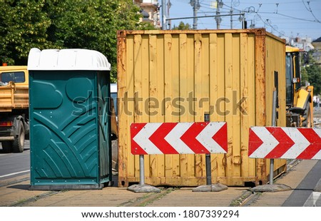 Freight transportation container and a portable toilet on the street
