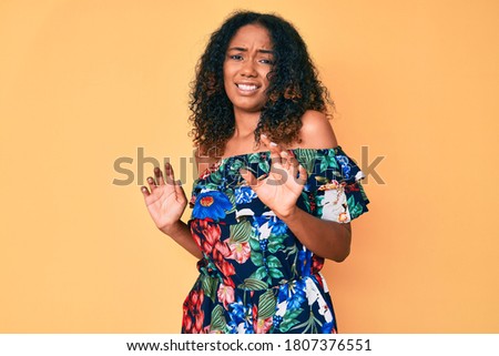Young african american woman wearing casual clothes disgusted expression, displeased and fearful doing disgust face because aversion reaction. with hands raised 