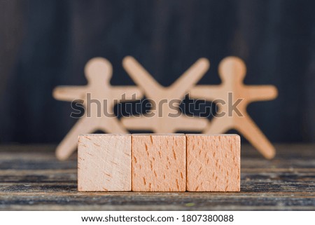 Marketing concept with wooden figures, cubes on wooden and grunge background side view. 
