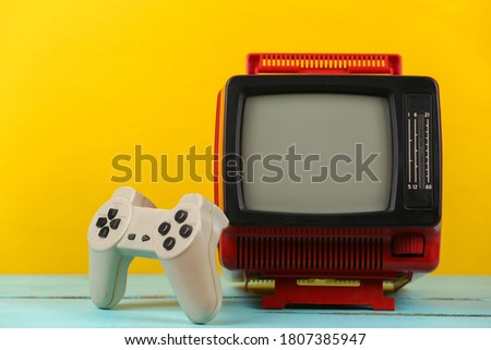 Retrogaming. Video game competition. Old TV with gamepad on yellow background. Attributes 80s