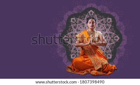 Indian woman in orange saree meditating over beautiful mandala background