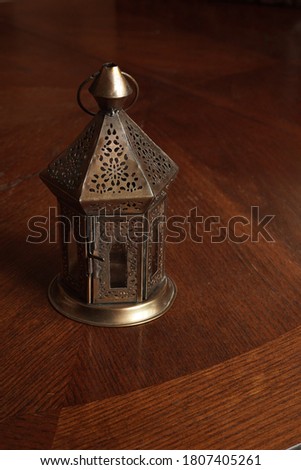 a bronze candlestick on a brown table.