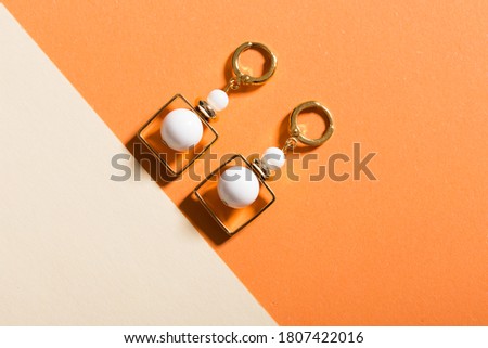 Top view of fashion jewelry and accessories on bright color background. Luxurious jewelry bijouterie and trendy concept.