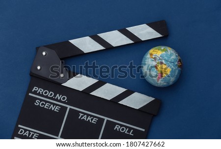 Movie clapper board with globe on classic blue background. Filmmaking, Movie production, Entertainment industry. Color 2020. Top view