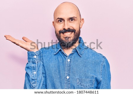 Young handsome man wearing casual clothes smiling cheerful presenting and pointing with palm of hand looking at the camera. 