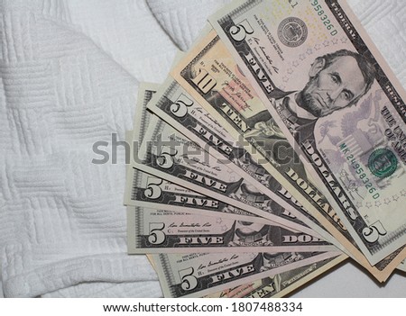 American dollars lying on a white coverlet of the bed