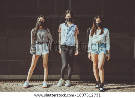 Image of a group of friends meeting outdoor and having fun. Taking photos with a dark background