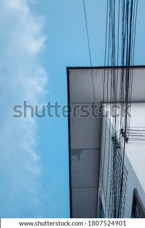 Electric cables pass roof of a house in Thailand. household cables that are neatly arranged.