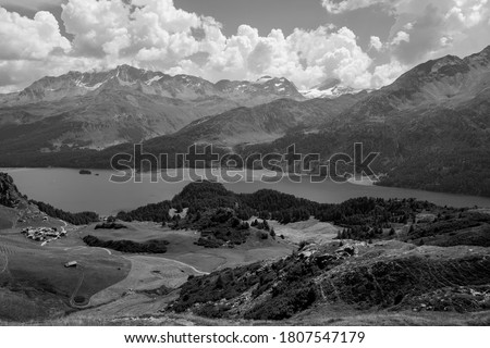 Black and white photo of Alps mountain panoramic scenery, with top view of Engadine lake valley.