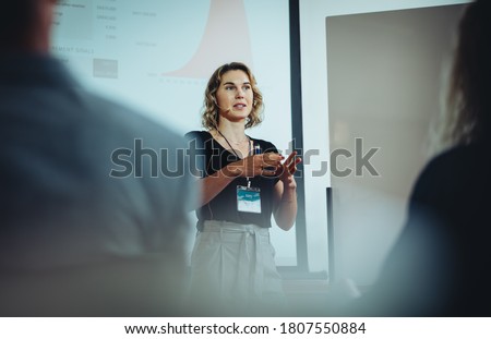 Woman entrepreneur discussing business ideas in a conference. Businesswoman giving presentation during a seminar.