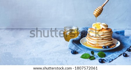 A stack of pancakes with fresh banana, blueberry and honey. Delicious homemade breakfast. Banner with copy space for text. Royalty-Free Stock Photo #1807572061
