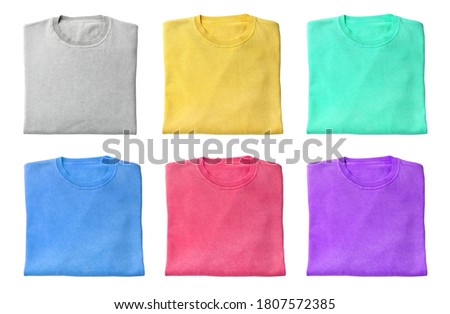Set of folded warm sweaters on white background, top view