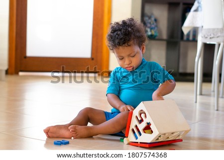 Beautiful african american toddler playing with wooden blocks Royalty-Free Stock Photo #1807574368