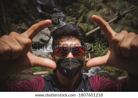 tourist taking selfie photo wearing a mask with stick carrying backpack ready for travel and adventure on vacations
