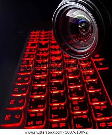 Glowing red keyboard Thai and English alphabet with lens of a camera.