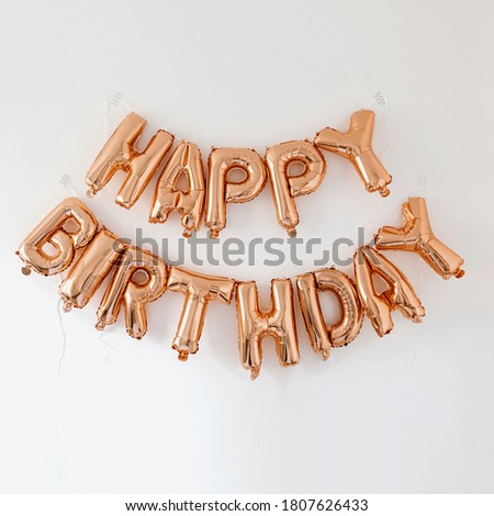Rose gold balloons Happy Birthday on white wall. Holiday anniversary party celebrating decoration