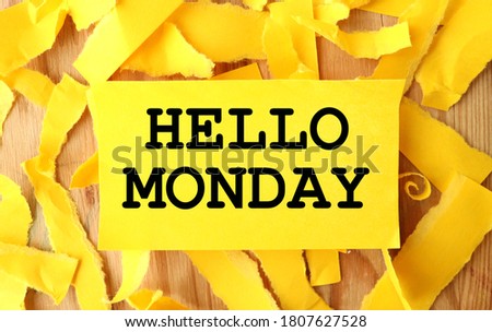hello monday. text on yellow paper on torn paper background