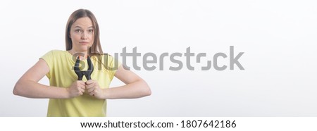 Young caucasian woman holding clamps over white background, studio shot, copy space, banner