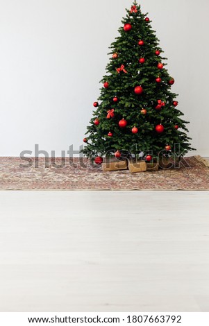 The interior of the white room is a green Christmas tree with red gifts for the new year decor winter holiday