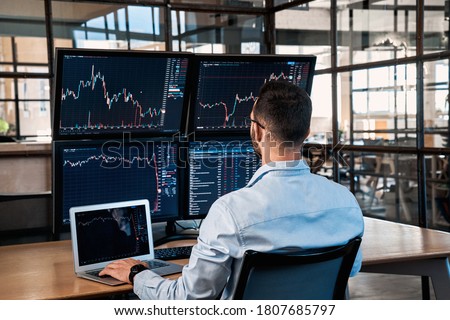 Successful trader working in modern office, looking at display, sale and buy bitcoin and analyzing index on cryptocurrency market diagram Royalty-Free Stock Photo #1807685797
