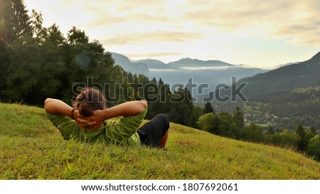 A tourist in the mountains, lying in the grass. Location Europe, Germany Royalty-Free Stock Photo #1807692061