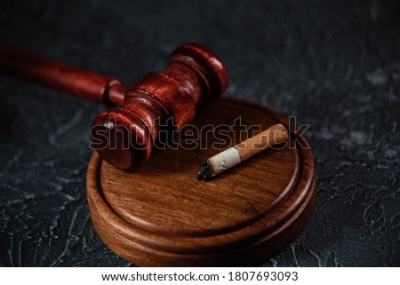 Judge gavel and broken cigarette on grey table. Tobacco law
