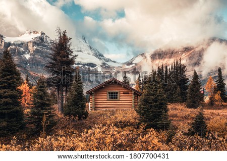 Wooden hut with Assiniboine mountain in autumn forest at provincial park, Canada Royalty-Free Stock Photo #1807700431