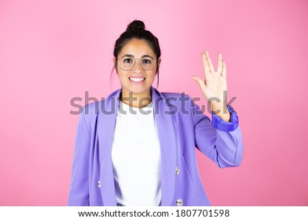 Young beautiful business woman over isolated pink background doing hand symbol