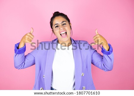 Young beautiful business woman over isolated pink background shouting with crazy expression doing rock symbol with hands up