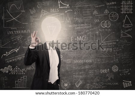 Businessman showing OK sign with lightbulb head in class