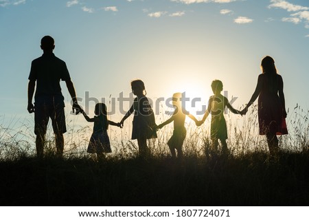 Silhouette of a happy large family at sunset.