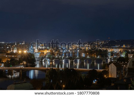 panorama of night city lights prague in the background are bridges on the river vltava on the river surface are reflections of lights at night