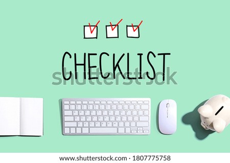 Checklist with a computer keyboard and a piggy bank