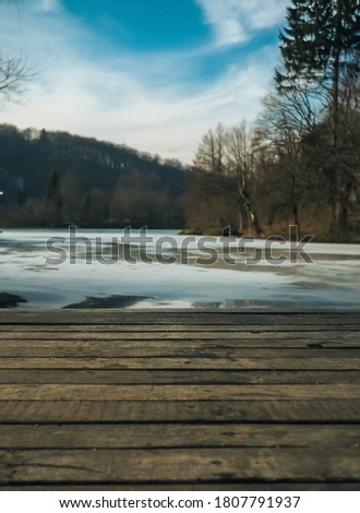 Wooden Bridge over the Lake with forest, mountain, and blue sky as background in Plitvice Lakes National Park, Croatia.