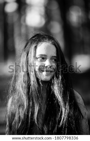 Portrait of a girl with long hair outdoors. Black and white photography.