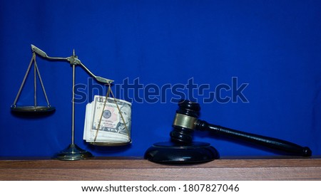 Golden scales with silver placed on the scale of justice, law scale and wooden hammer judge blue background