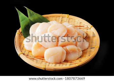 Scallops on bamboo colander and black background Royalty-Free Stock Photo #1807873669
