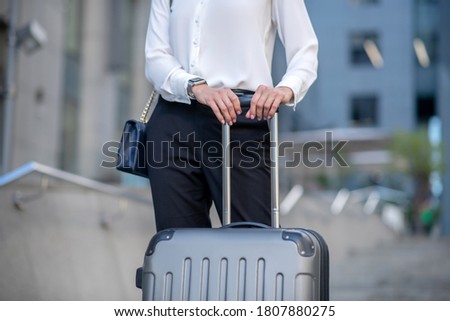 Travelling. Close up picture of a woman with a suitcase