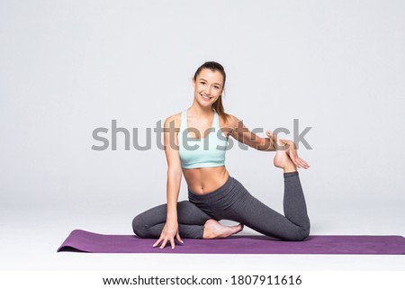 young beautiful woman yoga posing isolated over white studio background
